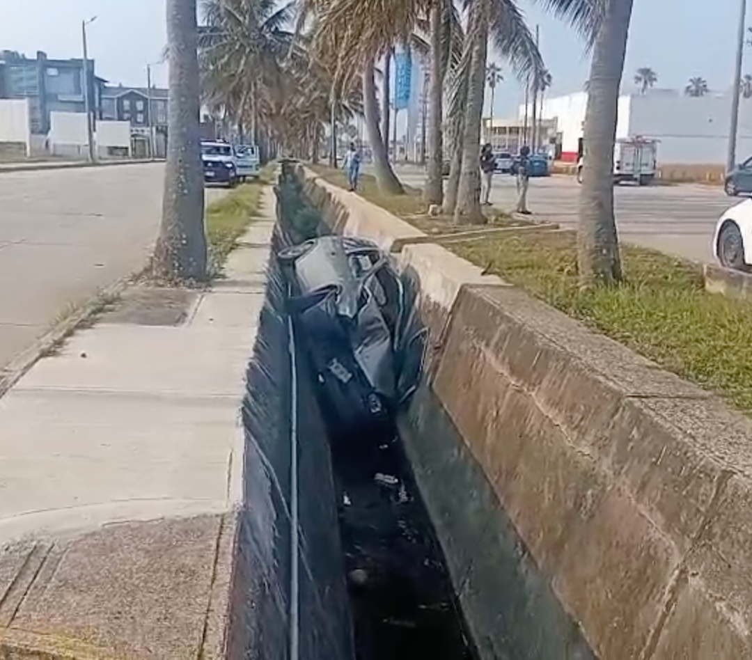 Auto cae a canal de aguas negras
